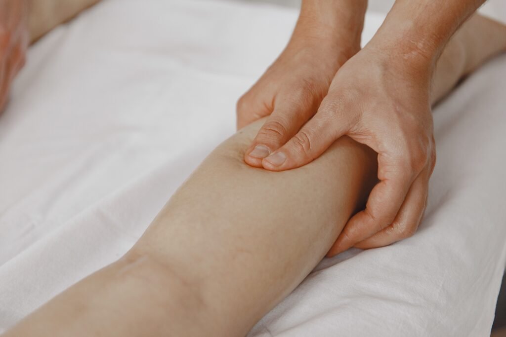 Close-up image of a massage therapist applying pressure on a client's leg for muscle relaxation.